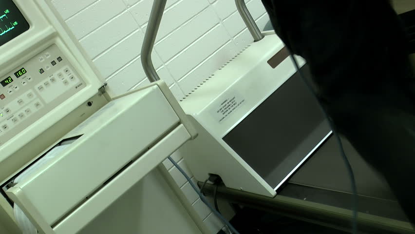 Male patient takes stress test, jogs on medical treadmill. 1080p