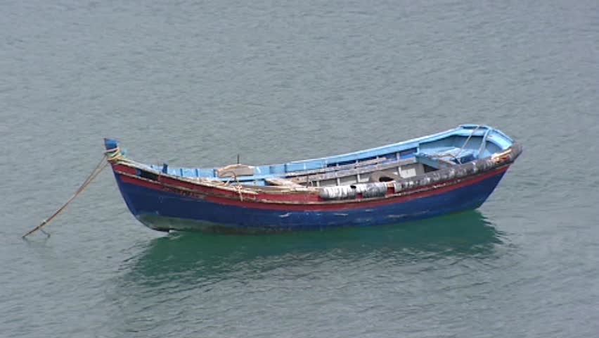 Fishing boat at anchor in sea - full screen.