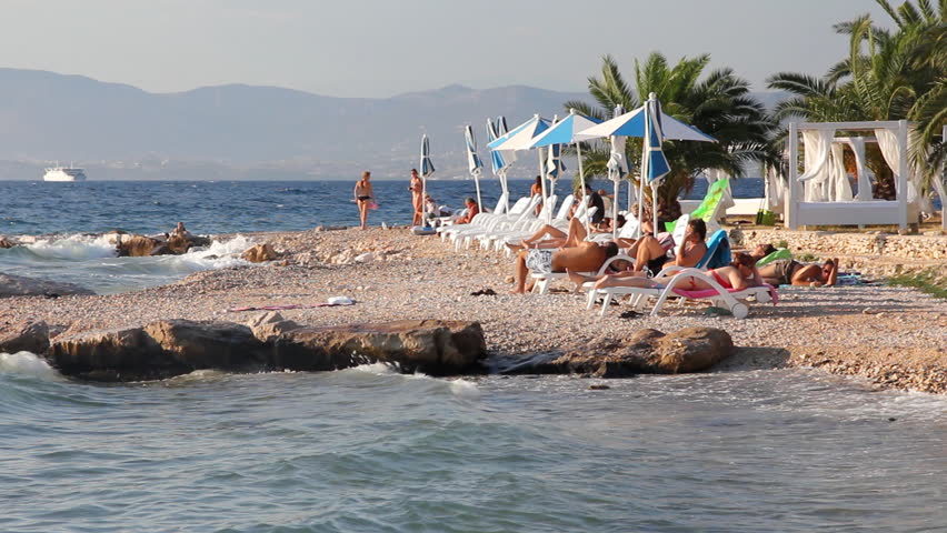 People on the beach, sunbathe and enjoy on vacation. Summertime at Adriatic Sea on the island Brac in Croatia