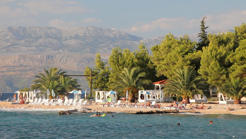 People on the beach, sunbathe and enjoy on vacation. Summertime at Adriatic Sea on the island Brac in Croatia