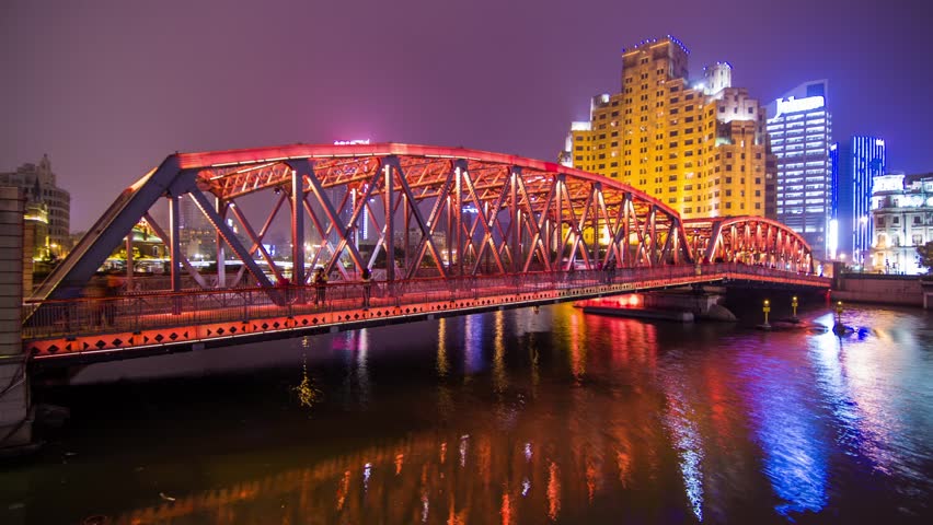 Time Lapse of a Steel Bridge Night Traffic View in The Bund, Shanghai, China. Traffic of People and Automobile on the Bridge as lights shifting color