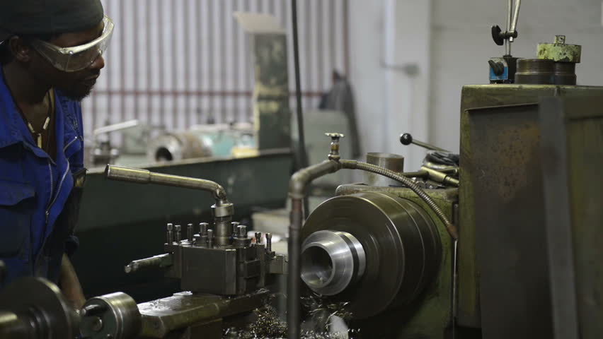 An industrial service repairmen labouring in workshop, selective focus, working on industry machine 