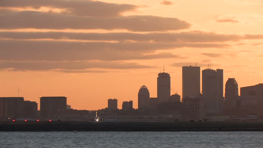 Airplane takeoff from Logan Airport, Boston at sunset