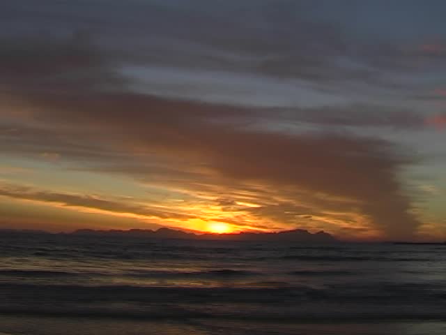 Timelapse clip of Sunset on the beach with clouds, blue sky and copy space. 