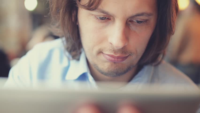 man using tablet computer touchscreen in cafe