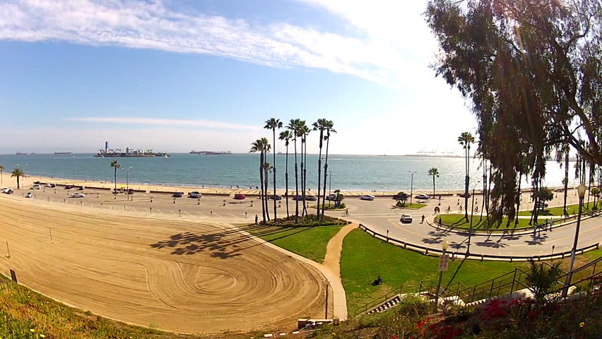LONG BEACH, CA - APRIL 2, 2013: A wide shot of the beach with palm trees, the Pacific Ocean (Long Beach Bay) and bicycle riders circa 2013 in Long Beach. Long Beach promotes bike riding and exercise.