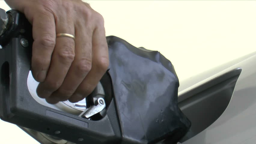 Hand squeezes gas nozzle, close up, removes from tank, screws on gas cap. 1080p