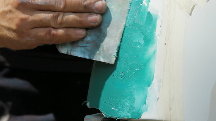 Close-up: smearing putty on damaged surface