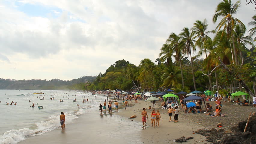 COSTA RICA - MAR 2013: Mostly local "Ticos" gathered on a beach just outside Manuel Antonio National Park in Quepos, Costa Rica in March, 2013.