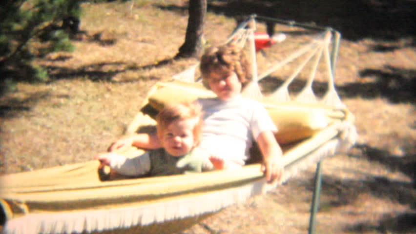 MOOSIC, PENNSYLVANIA, 1968: Loving sisters enjoy spending time together swinging on the hammock in the summer of 1968.