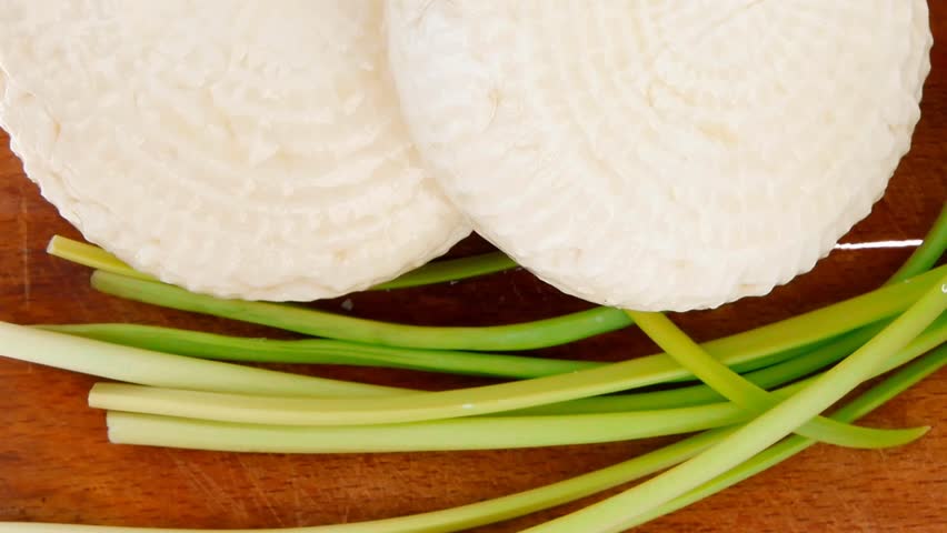 diet food : greek feta white cheese served on small wooden plate isolated over white background