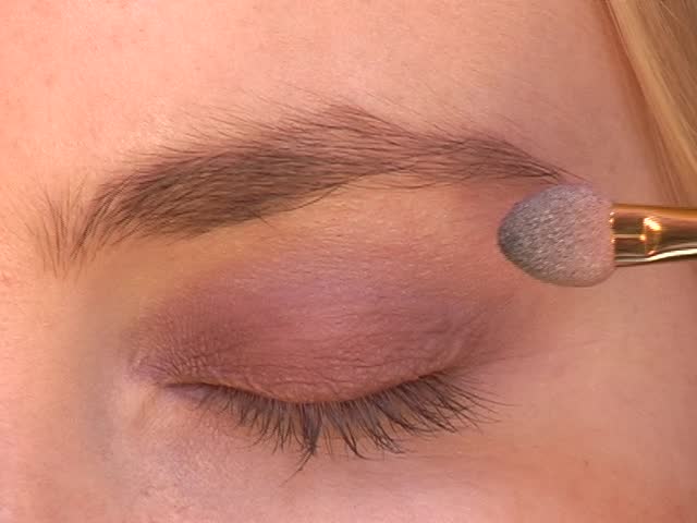 Make-up artist applying cosmetics to woman