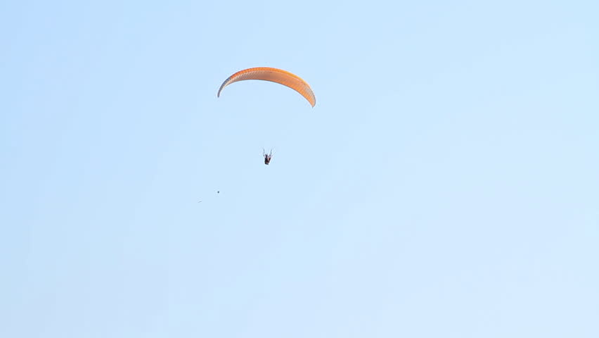 Paragliding over the mountains against clear blue sky