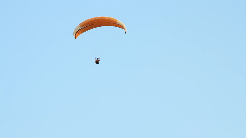Paragliding over the mountains against clear blue sky