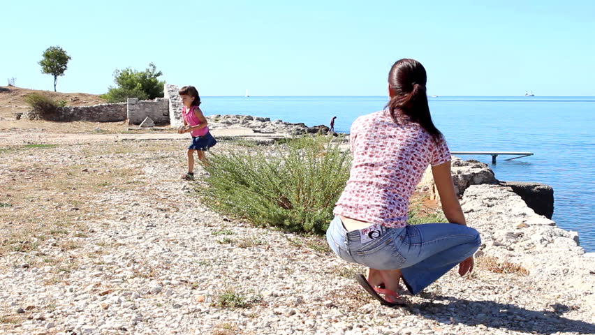 Look mom - Child and mother throwing pebbles.