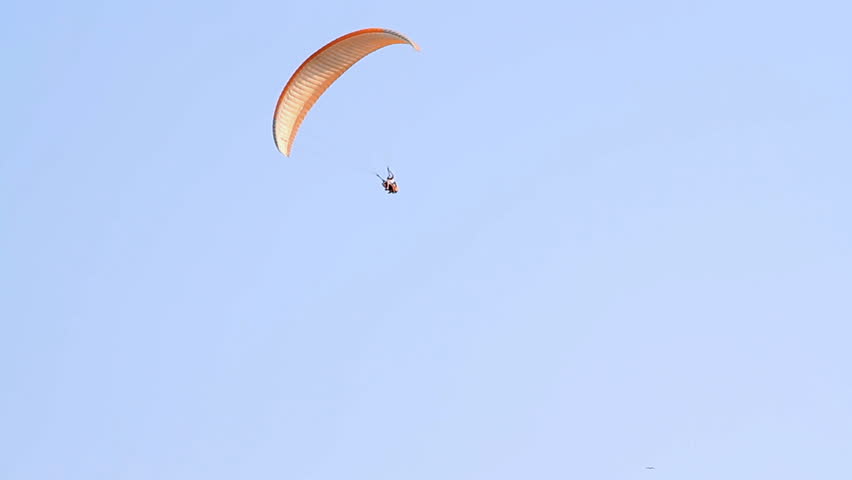 Paragliding over the mountains against clear blue sky