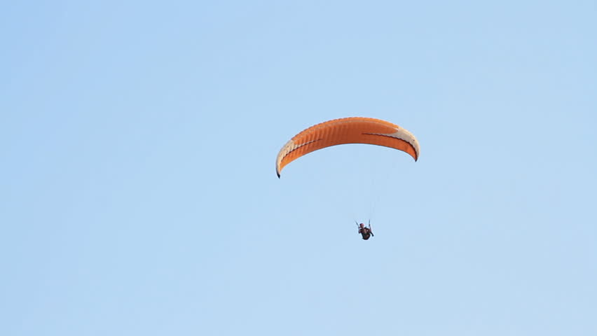 Paragliding over the mountains against clear blue sky