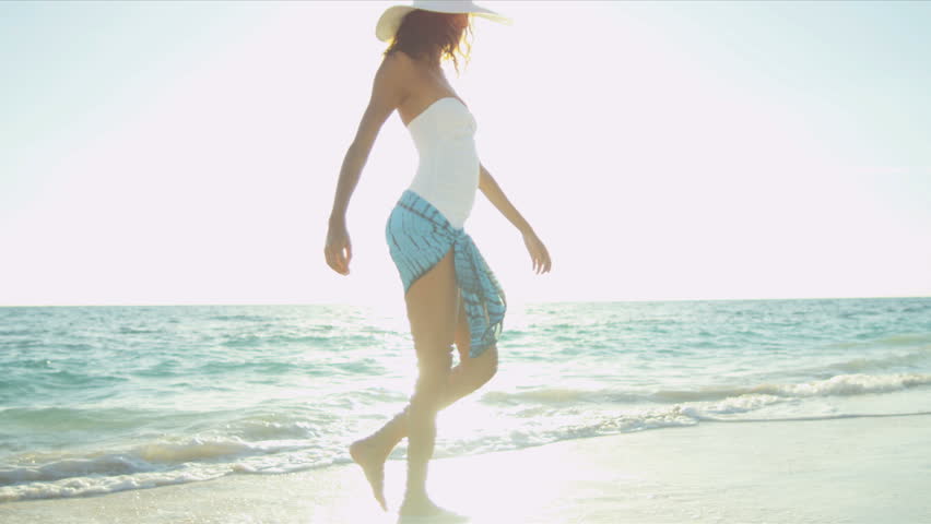 Pretty girl in swimsuit reveling being alone by ocean on remote island beach shot on RED EPIC