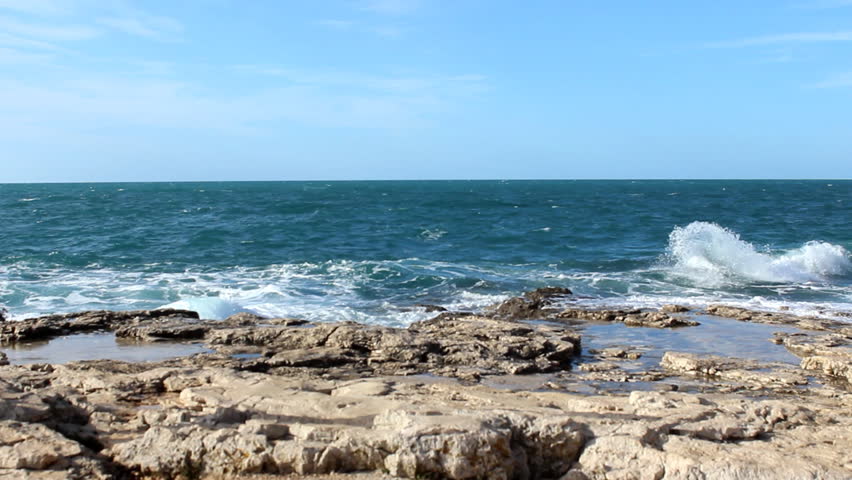 Rocky walk - Woman hopping on the coast.                