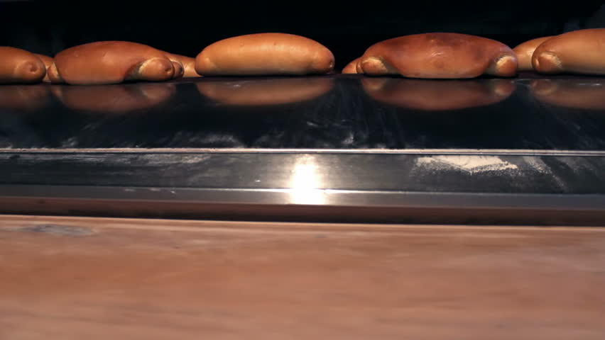 Oven for baking bread ; warm baked bread at the exit of the oven,video clip