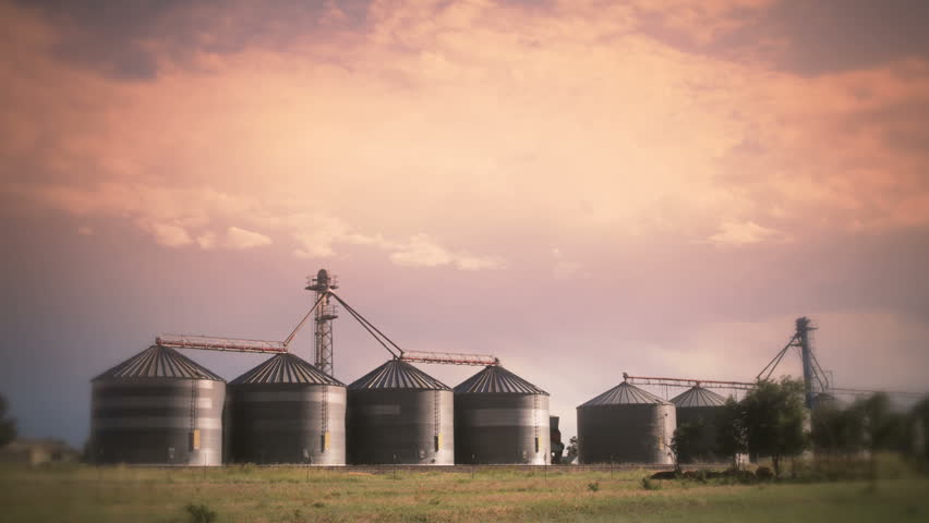 Stylized timelapse of a thunderstorm and clouds over silos in a rural setting. HD 1080p timelapse.