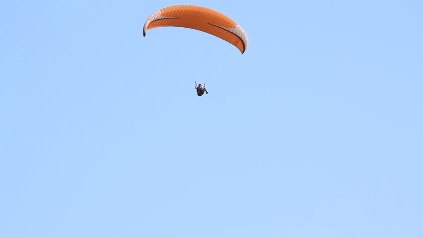Paragliding over the mountains against clear blue sky