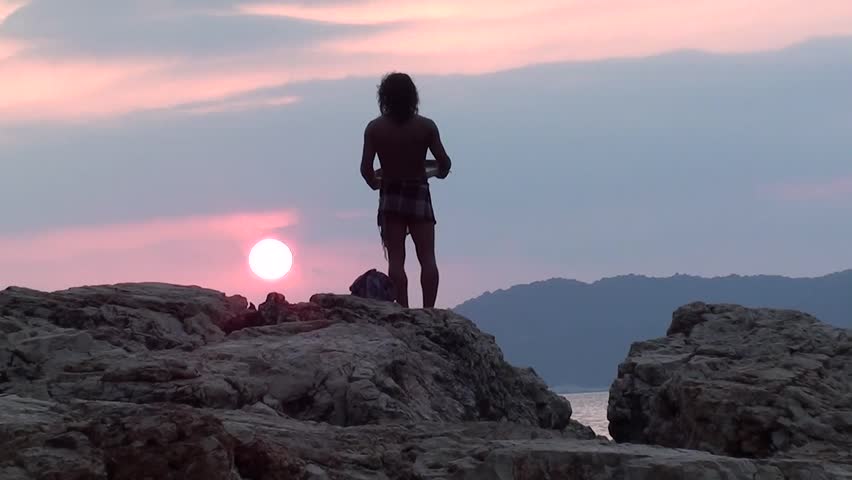 KAS, TURKEY â 12 August 2012: Aboriginal music concert at the Buyuk Cakil Beach - Man with tambourine praying to declining sun, audio