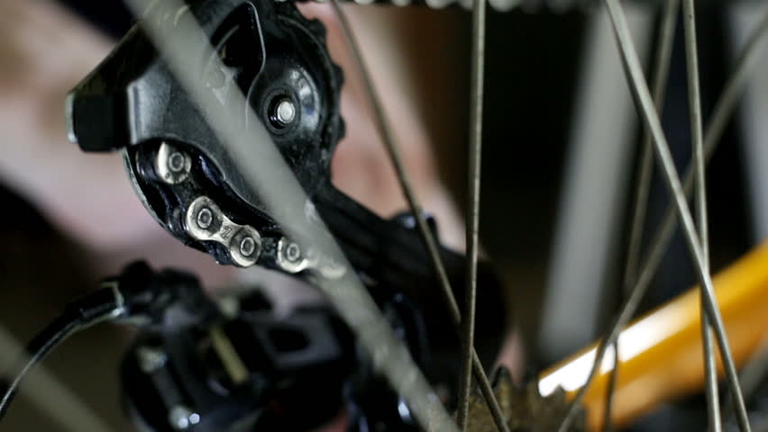 A man cleaning bicycle chain with cloth, later oiling the clean chain. Extreme closeup with macro tubes and high quality shoot.