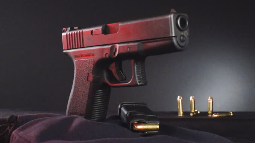 Semi-automatic Pistol in focus as it rotates.