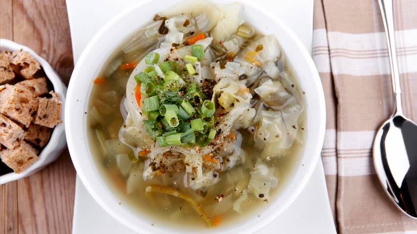 hot fresh diet vegetable soup with rye bread crackers over wood table ceramic stand 1920x1080 intro motion slow hidef hd