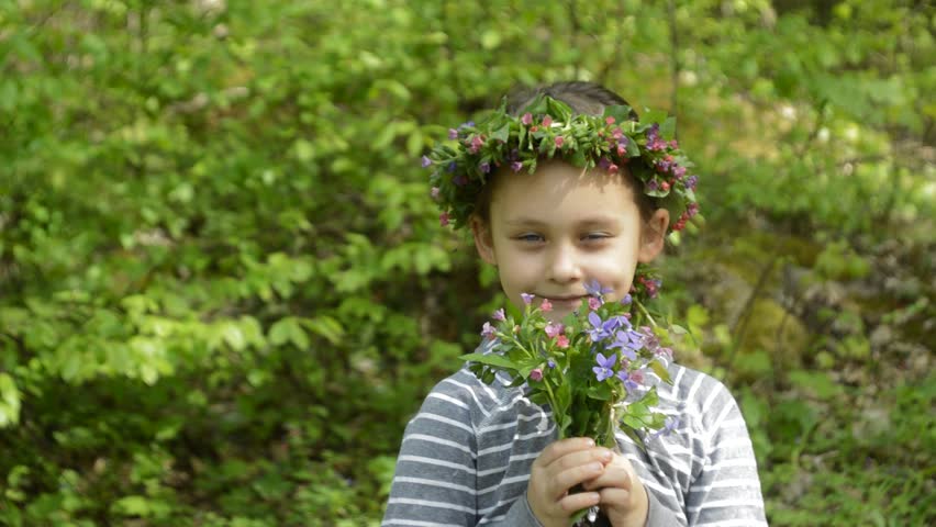 little girl with a wreath of flowers on her head and a bunch of flowers
