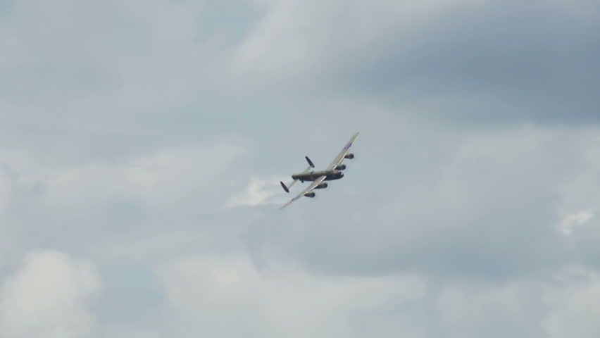 Avro Lancaster bomber plane from World War II flies around towards camera in a wide banking manoeuvre.