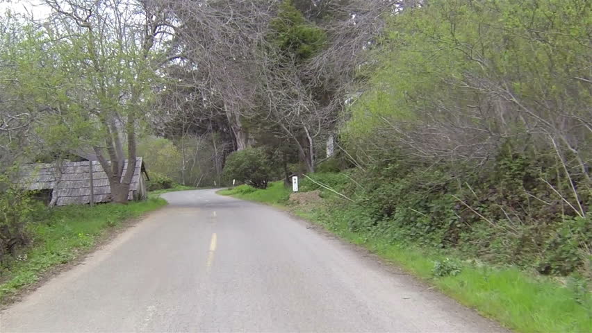 Driving rural road forest foggy mountain California. Driving point of view a car or vehicle on a foggy stormy rural road along the coast. Farm land and ranch property. Dense fog weather heavy mist.