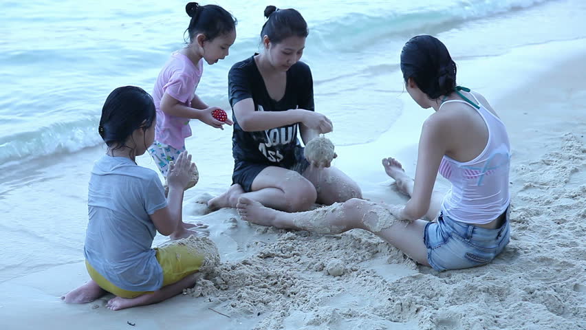 Happy family building sand castles on the beach