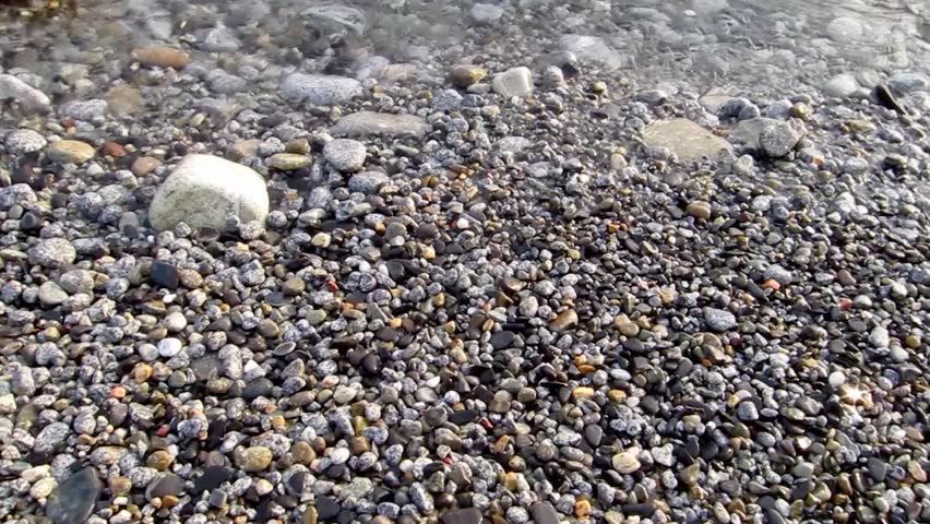 light blue water from the Mediterranean sea, with pebbles and rocks, from a beautiful beach in the island of Elba in Tuscany, Italy