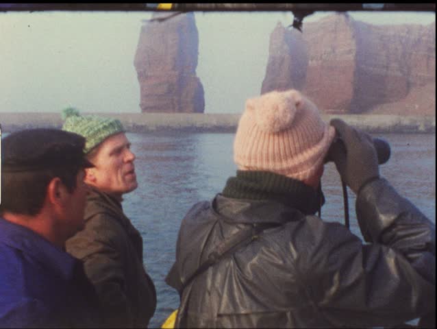 HELGOLAND, GERMANY - CIRCA 1970s: Group of people on boat take trip to Helgoland, Germany circa 1970s. Vintage 8mm film.