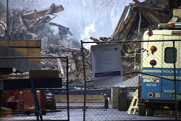 NEW YORK CITY - SEPTEMBER 28, 2001: World Trade Center rubble with smoke rising seen behind security gate.