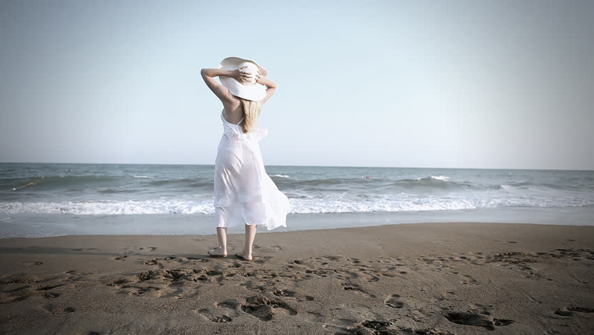 Young beautiful women in white on the beach