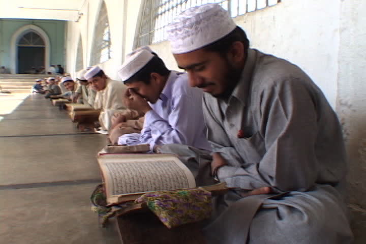 PESHAWAR, PAKISTAN - NOVEMBER 01, 2001: Row of young men in Muslim dress rock back and forth as they read the Koran.