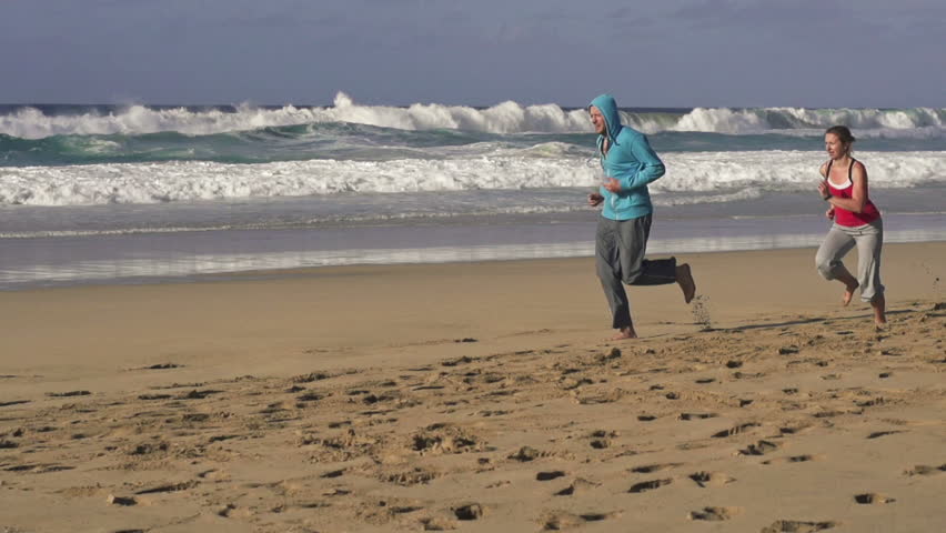 Couple jogging, race on the beach
