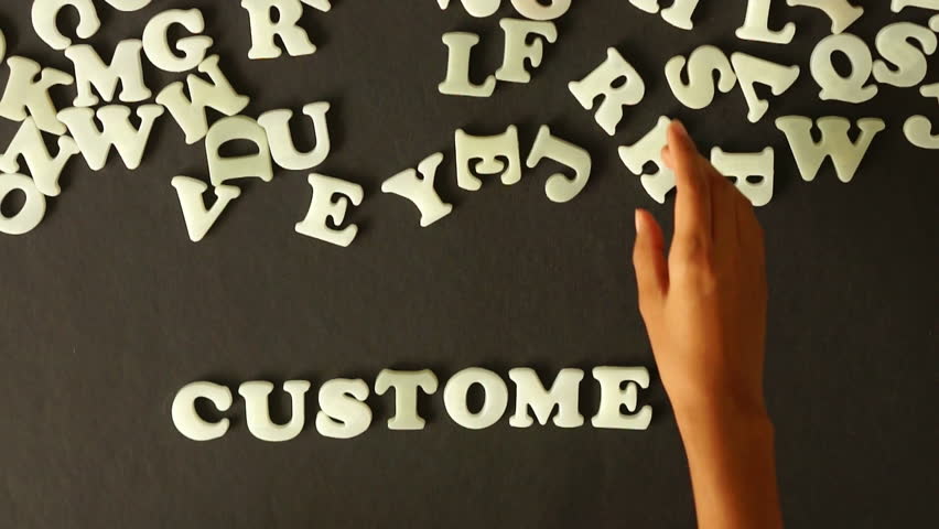 A person spelling Customers with plastic letters
