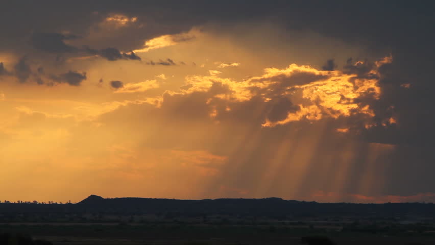 SOUTH AFRICA - CIRCA 2012 - Sun piercing the clouds in savannah