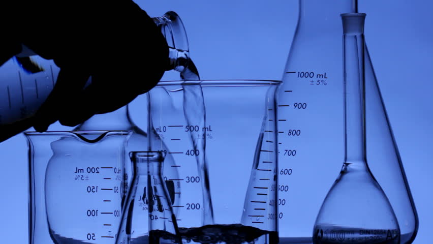 Close up HD video of scientist pouring chemical into flask, shot in HD video with an overall cool cast