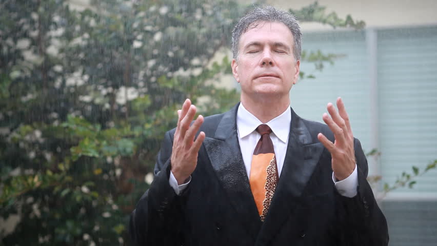 A sudden rain shower drenches a weary businessman with no umbrella for protection.