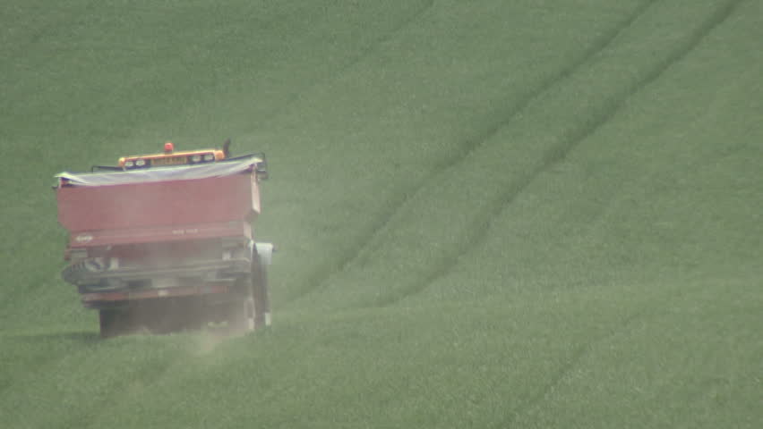 Spraying fertiliser pellets on a cereal crop. HD.