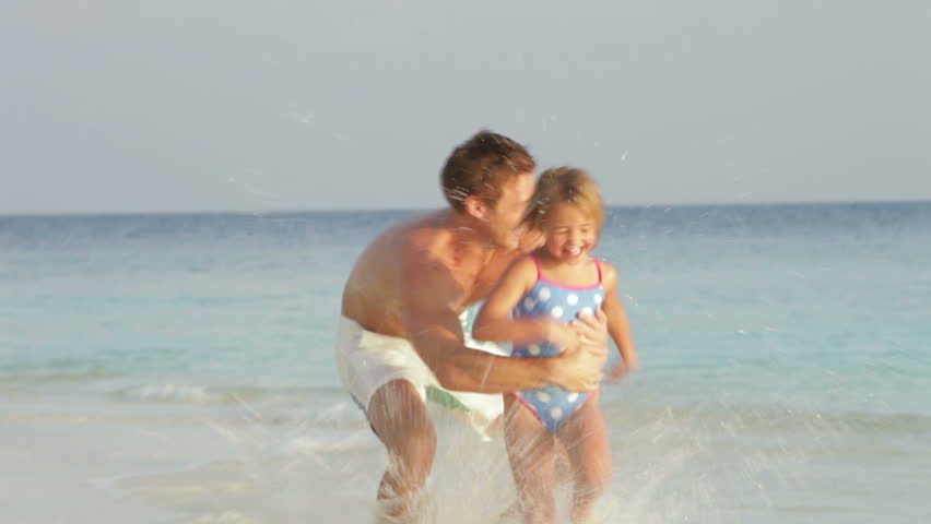 Father And Daughter Having Fun In Sea On Beach Holiday
