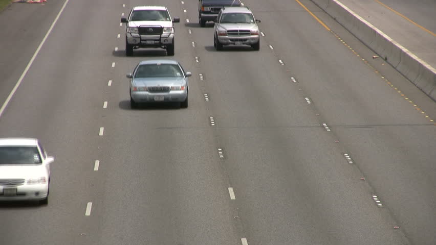 Video of vehicle, car and truck traffic driving towards view from overpass. High speed multiple lane freeway highway. San Antonio Texas. Don Despain of Rekindle Photo