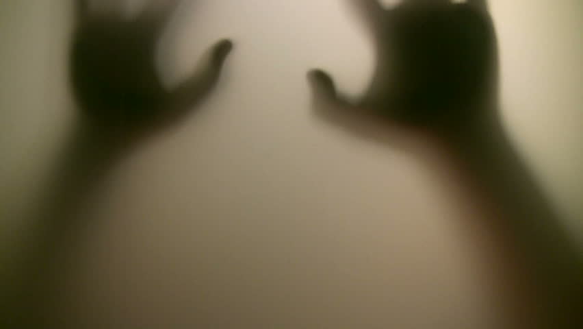 Victim. Terrified hands behind glass