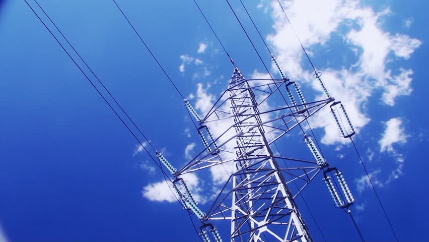 High voltage tower on cloudy sky in time lapse motion