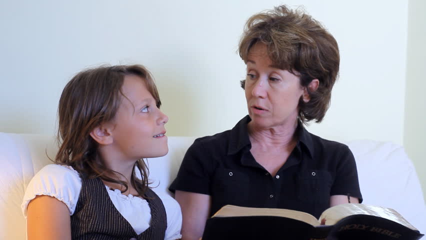 A granddaughter listens to her grandmother tell her a story from the bible.